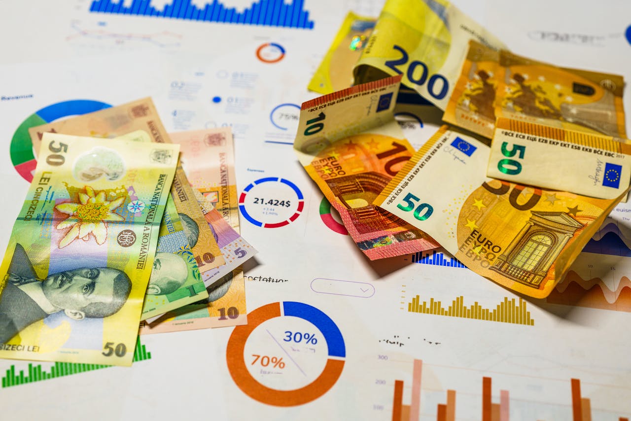 Colorful Euro and Romanian Lei banknotes on top of financial charts, symbolizing currency exchange and economic analysis.